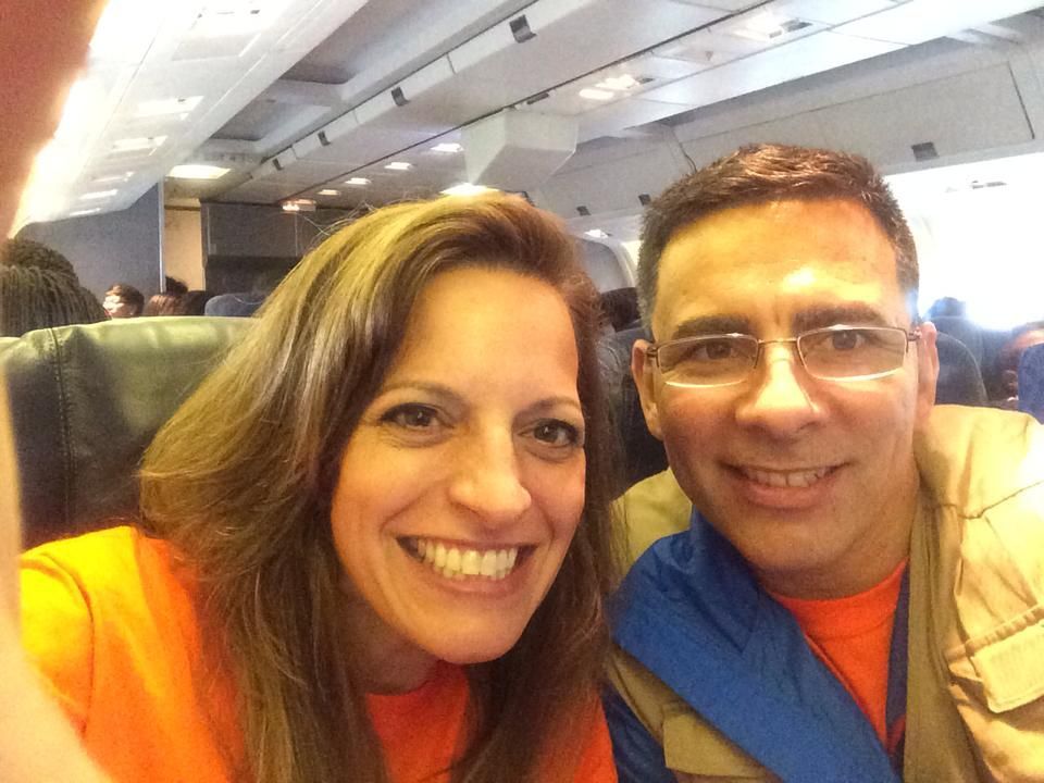 A man and a woman are posing for a picture on an airplane