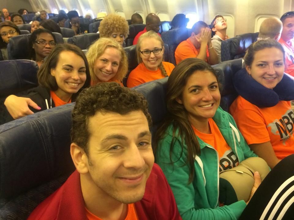 A group of people are sitting on a plane wearing shirts that say abe