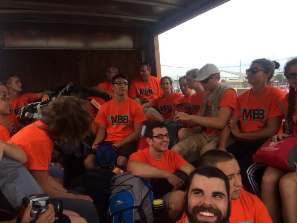 A group of people wearing orange shirts with mbb on them