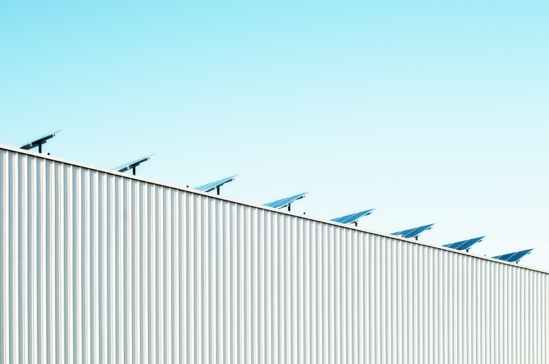 A Row of Solar Panels on the Roof of a Building — DLG Electrical and Solar In Wyong, NSW
