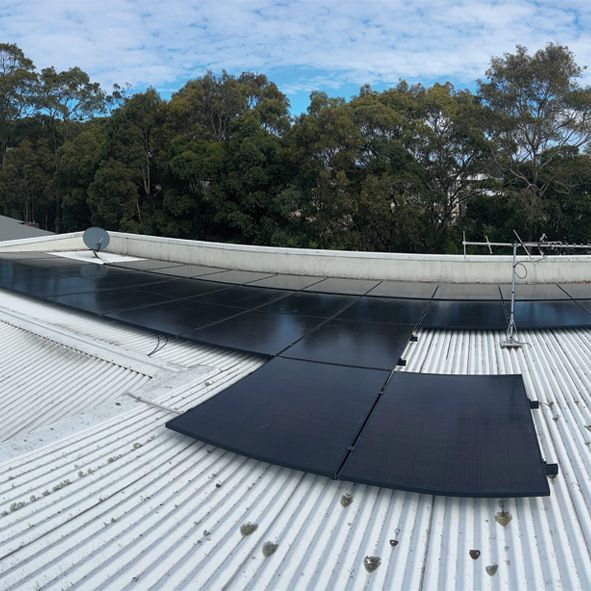 A White Roof With Black Solar Panels on It — DLG Electrical and Solar In Wyong, NSW