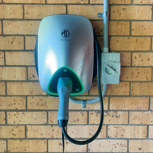 A MG Electric Car Charger Mounted on a Brick Wall — DLG Electrical and Solar In Wyong, NSW