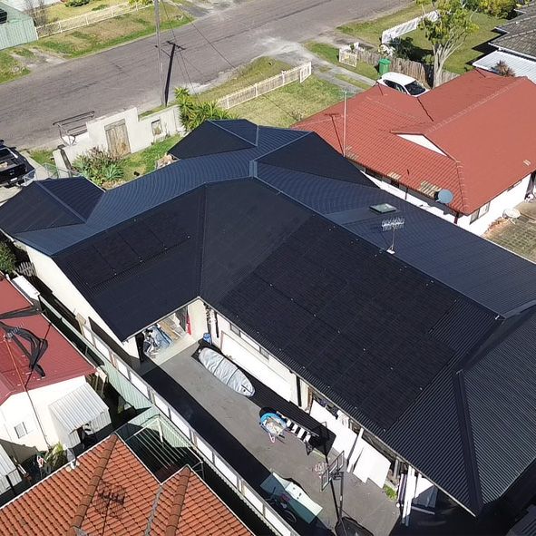 An Aerial View of a House With a Black Roof and a Red Roof — DLG Electrical and Solar In Wyong, NSW