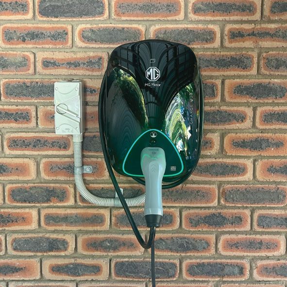 A Electric Car Charger is Mounted on a Brick Wall — DLG Electrical and Solar In Wyong, NSW