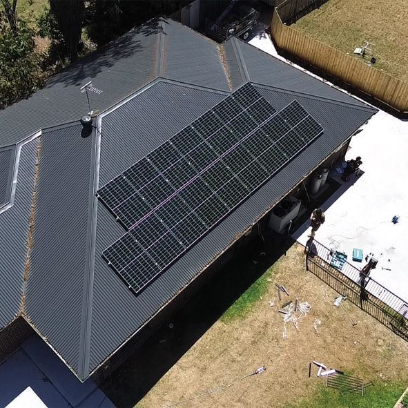 An Aerial View of a Black Roof With Solar Panels on it — DLG Electrical and Solar In Wyong, NSW
