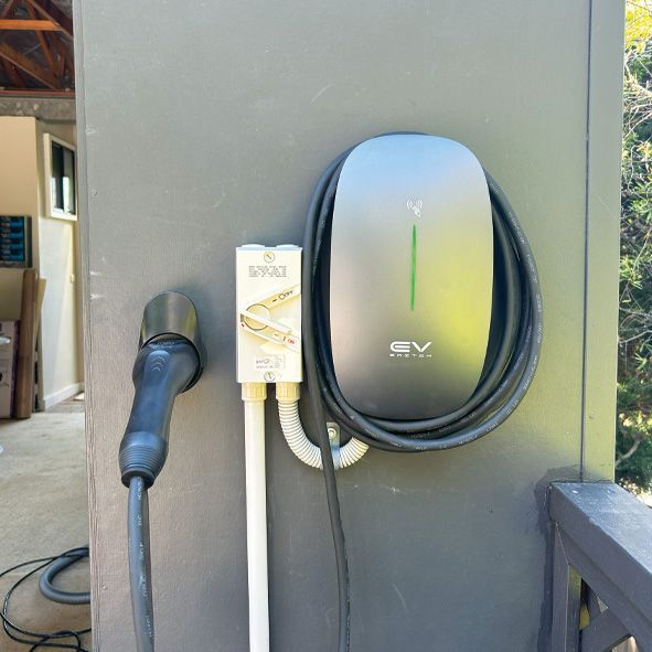 A Ev Charging Station is Attached to the Side of a Building — DLG Electrical and Solar In Wyong, NSW