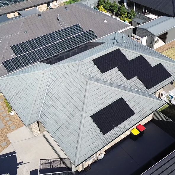 An Aerial View of a House Under Construction With Solar Panels on the Roof — DLG Electrical and Solar In Wyong, NSW
