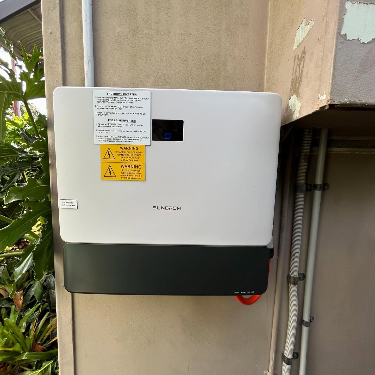 A White Battery Box With a Yellow Sticker on It is Hanging on a Wall — DLG Electrical and Solar In Wyong, NSW