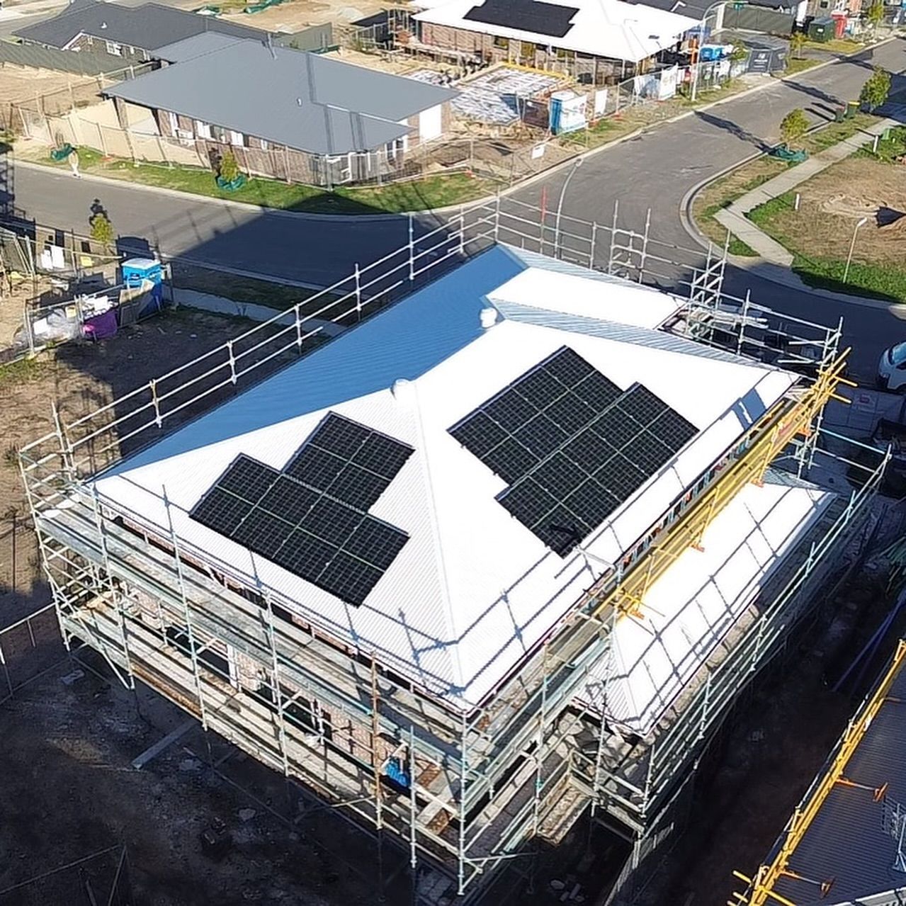An Aerial View of a White House With Solar Panels on the Roof — DLG Electrical and Solar In Wyong, NSW
