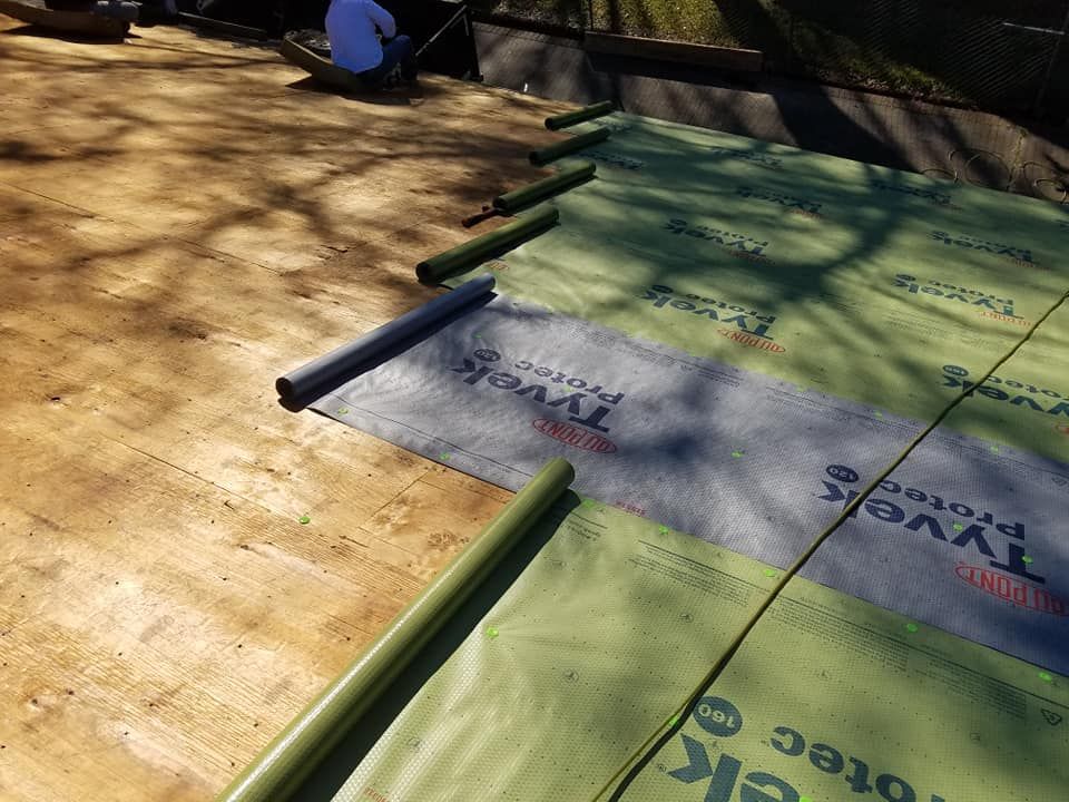 A roof is being covered with a roofing material.
