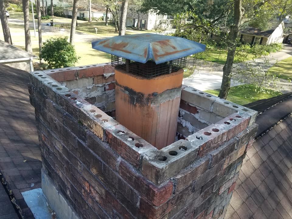 A brick chimney with a blue cap on top of it.