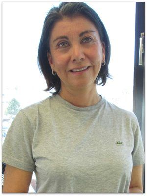 A woman wearing a grey lacoste shirt smiles for the camera