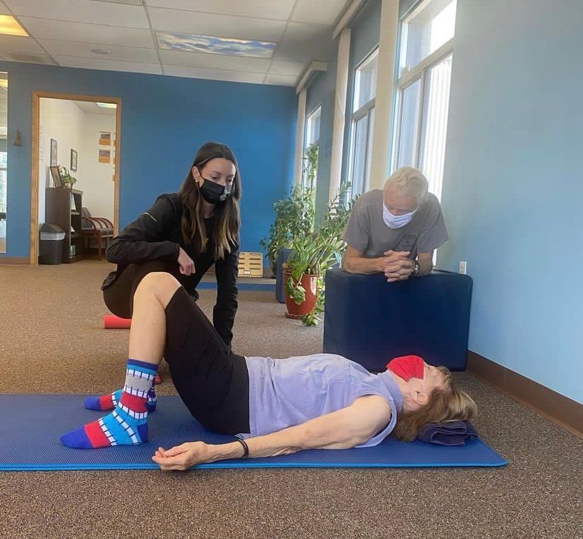 a woman is doing sit ups on a mat in a gym .