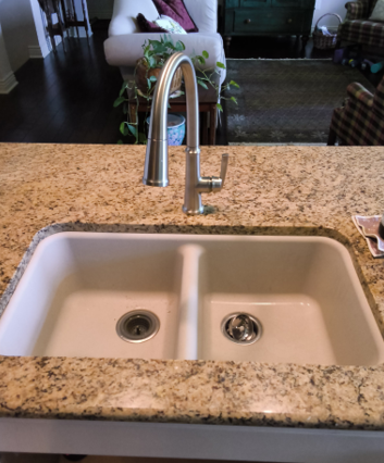 Kitchen sink with granite countertop and chrome faucet in a home interior.