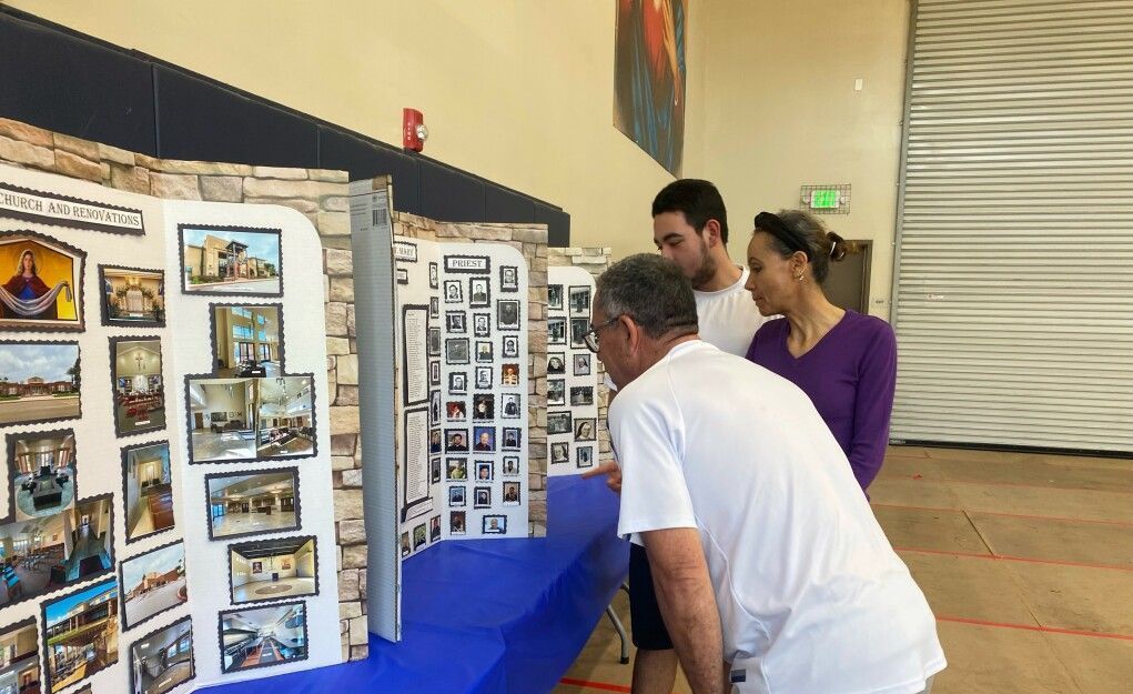 People viewing photo displays at a table in a hall