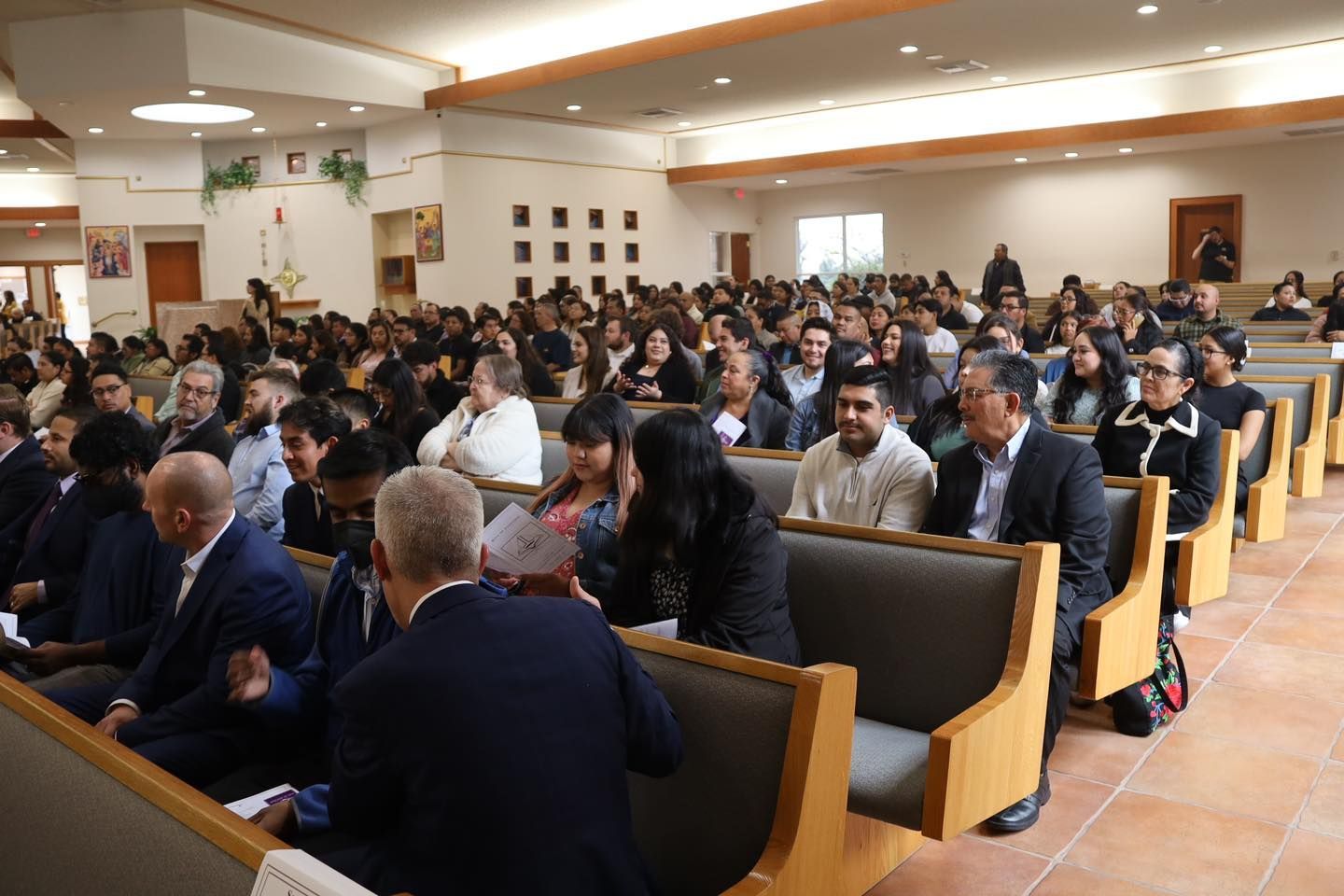 Audience seated in a bright hall during a formal event or lecture