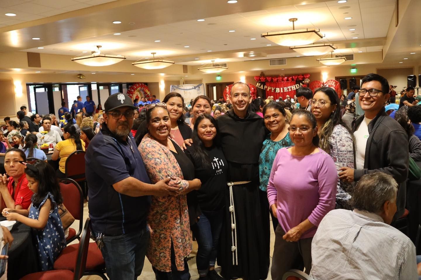 Group of people smiling and posing together at a banquet hall event