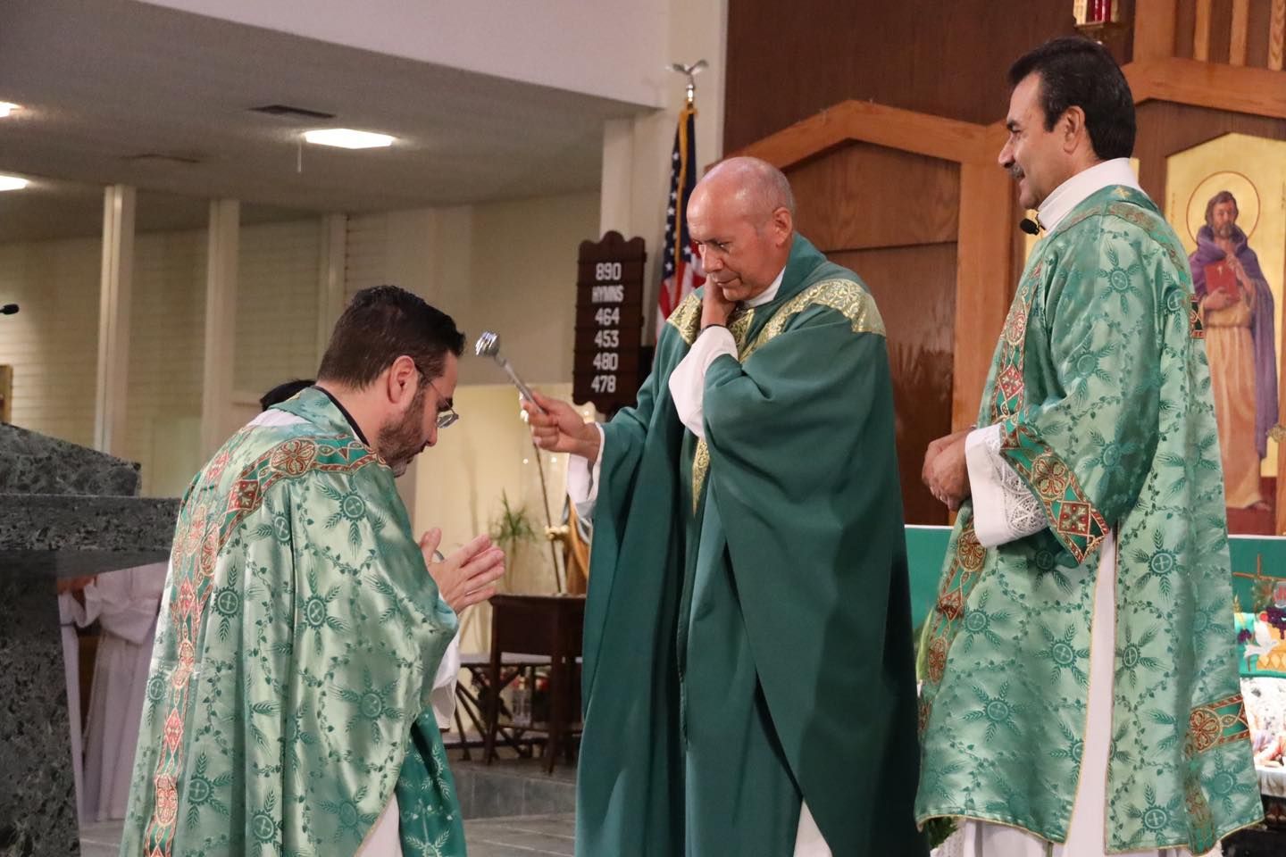 Priests in green vestments at the altar during a church service