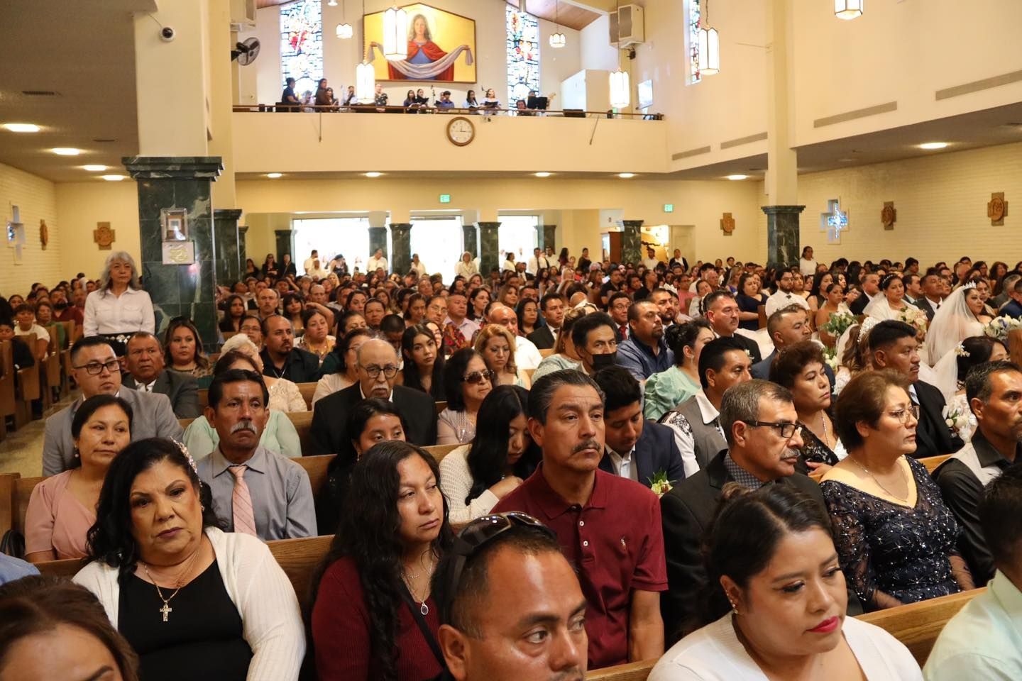 Large crowd seated in a church hall, facing the front during a service or event.