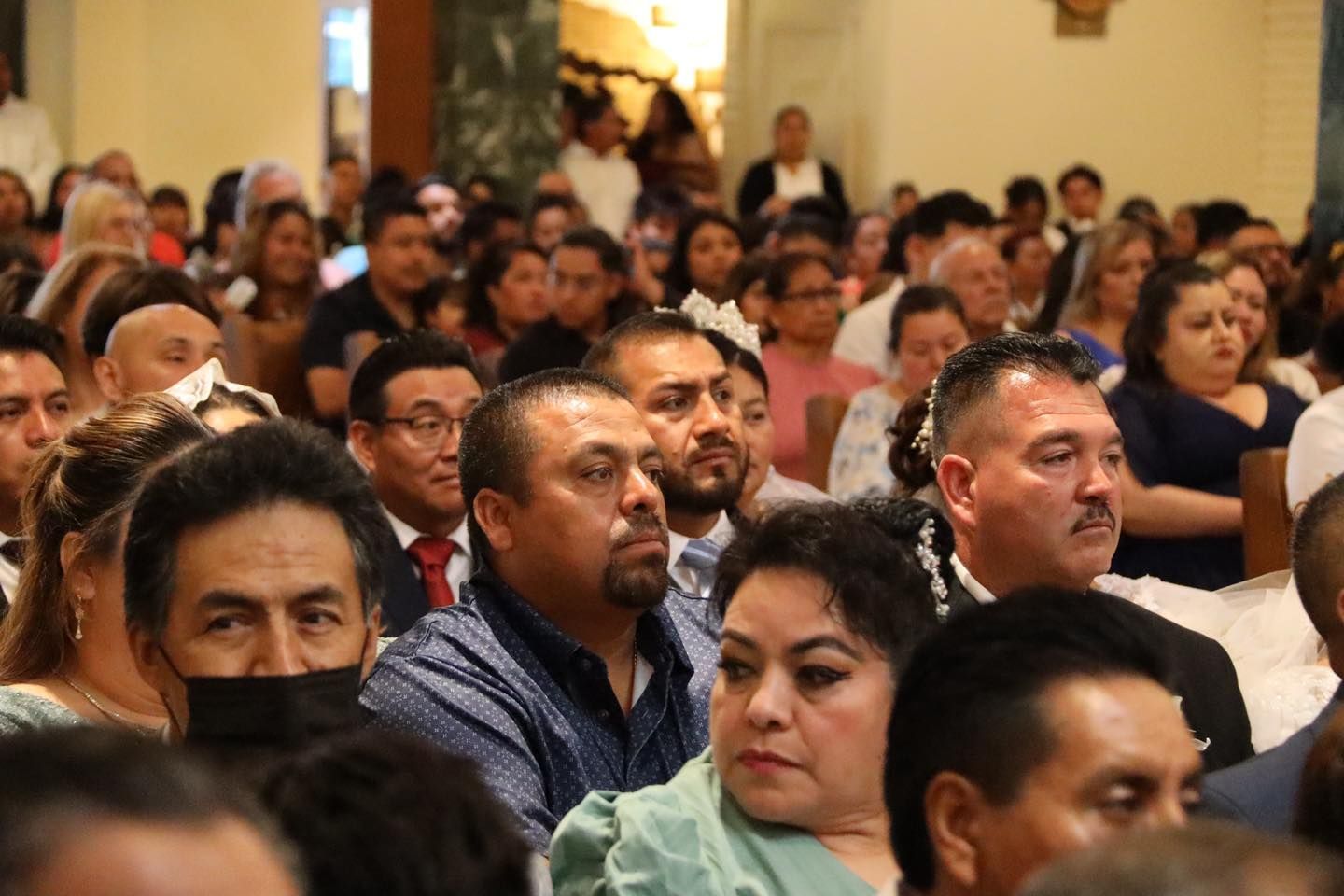 Audience seated in a hall, listening attentively during a meeting or presentation.