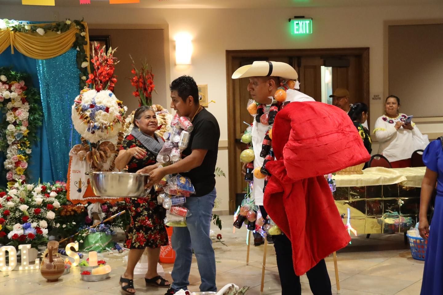 People in festive costumes sharing gifts at a holiday event indoors
