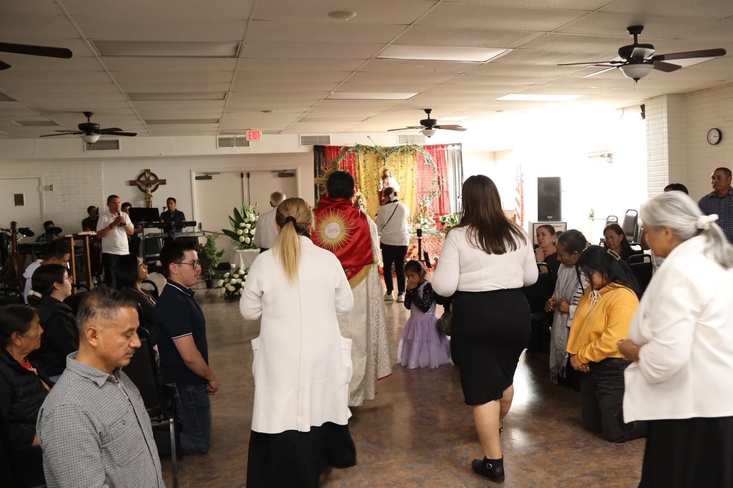 People gathered in a hall, walking and dancing during a lively indoor event.