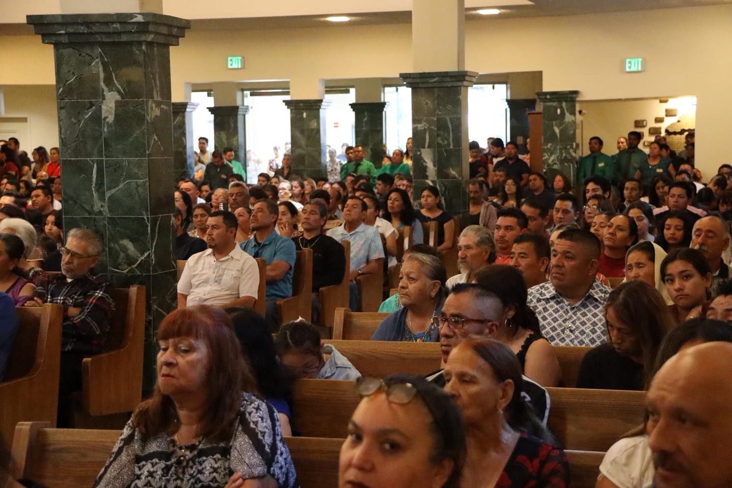 Crowded church hall with seated audience listening attentively during a gathering