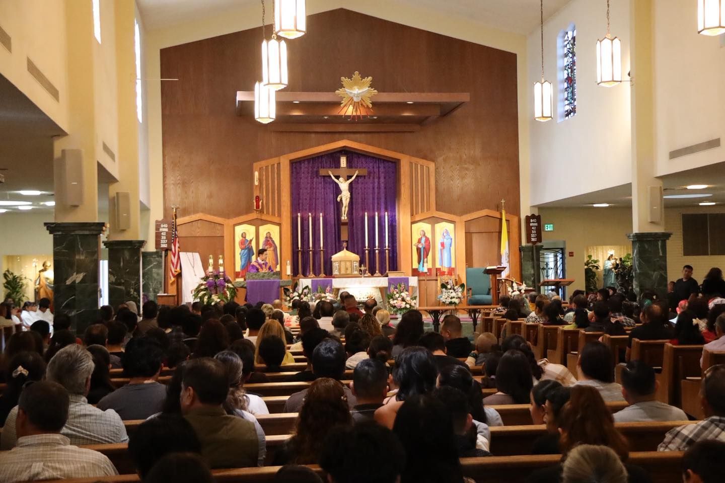Congregation seated in a church, facing a purple-draped altar during a service