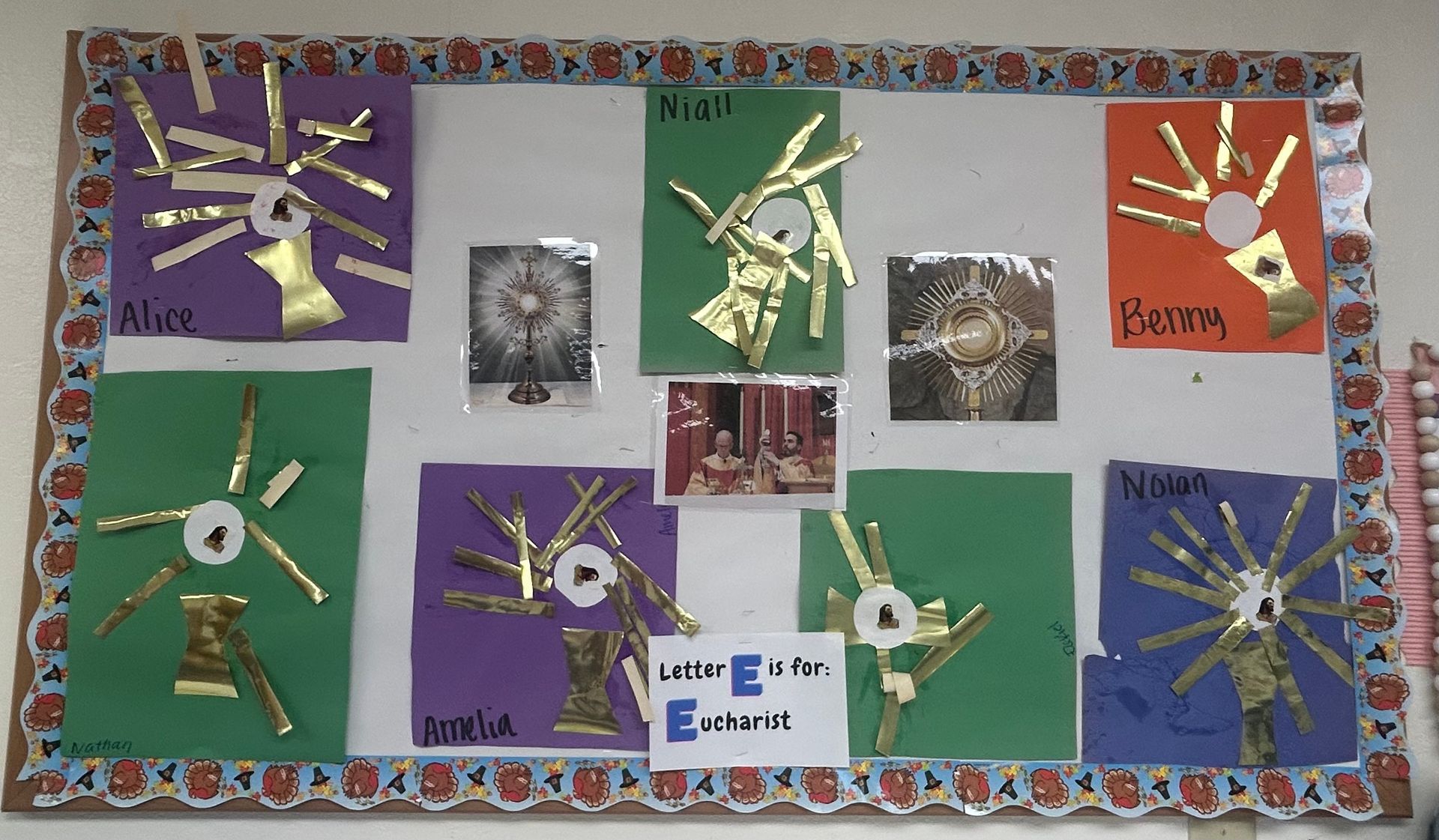 Colorful classroom bulletin board with handmade paper cutouts and small photos, framed by a patterned border