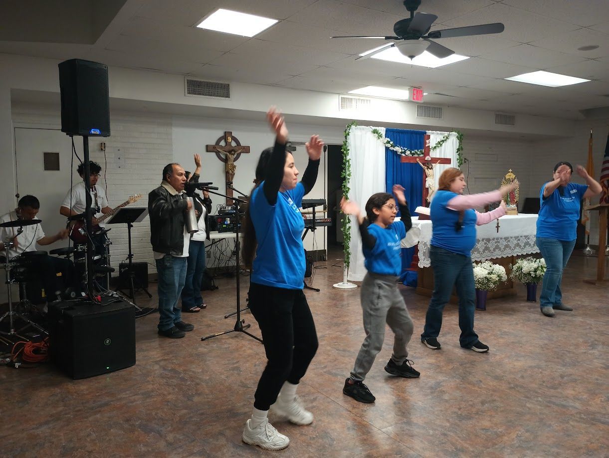 People dancing in a community hall while a live band plays on stage