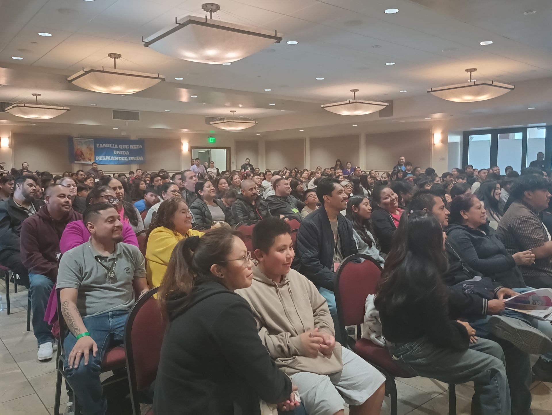 Audience seated in a conference hall, facing a presentation off-camera