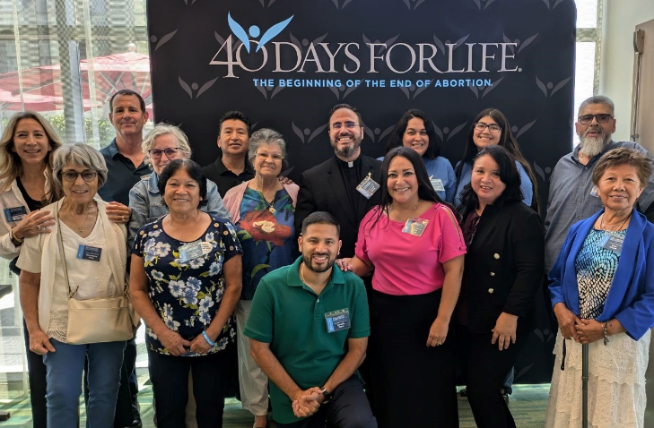 Group photo at a 40 Days for Life event with attendees standing in front of a banner