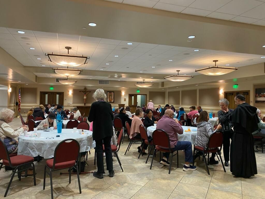 Banquet hall with people seated at round tables during a social gathering