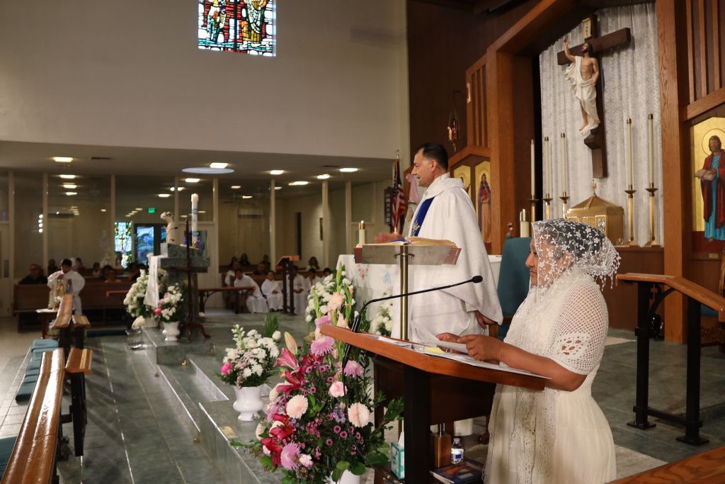 Wedding ceremony in a church, with a priest at the altar and a bride seated nearby.