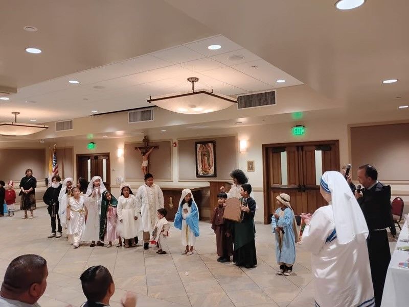 People in white robes and formal attire standing in a banquet hall during a group ceremony