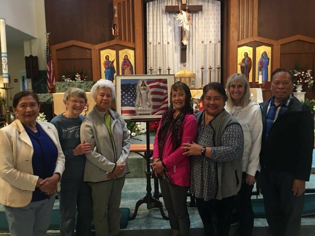 Group of people posing in a church sanctuary in front of the altar and American flag.