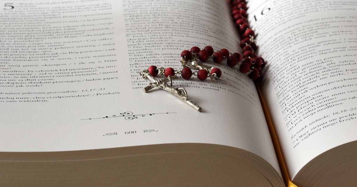 Open book with a red-beaded rosary resting across the pages