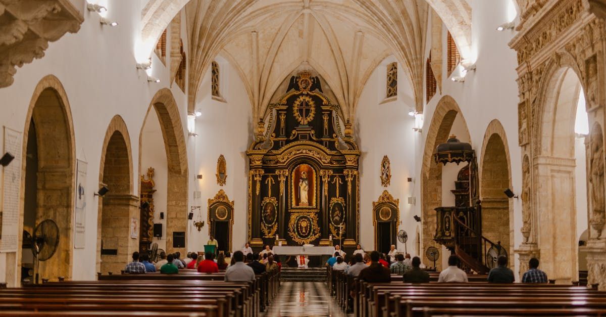 Ornate church interior with vaulted ceilings, wooden pews, and a gilded altar at the far end