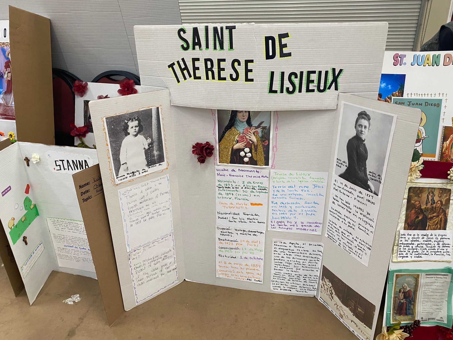 Tri-fold Saint Thérèse de Lisieux display board with photos, notes, and religious images