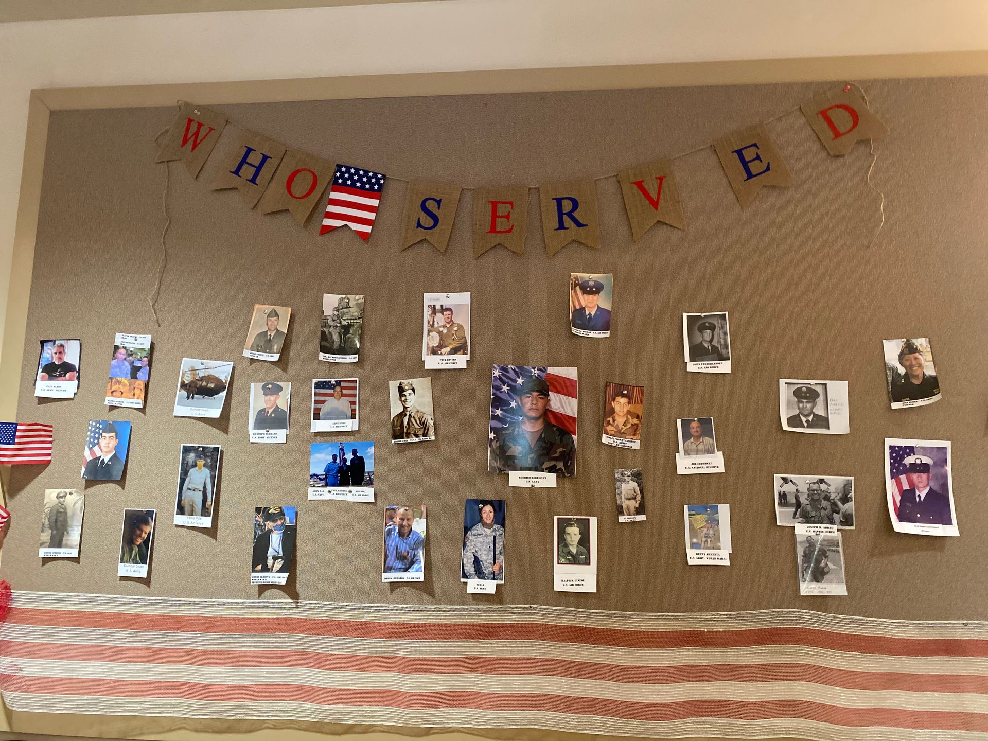 “WE HONOR SERVED” bulletin board with photos and patriotic red, white, and blue decorations