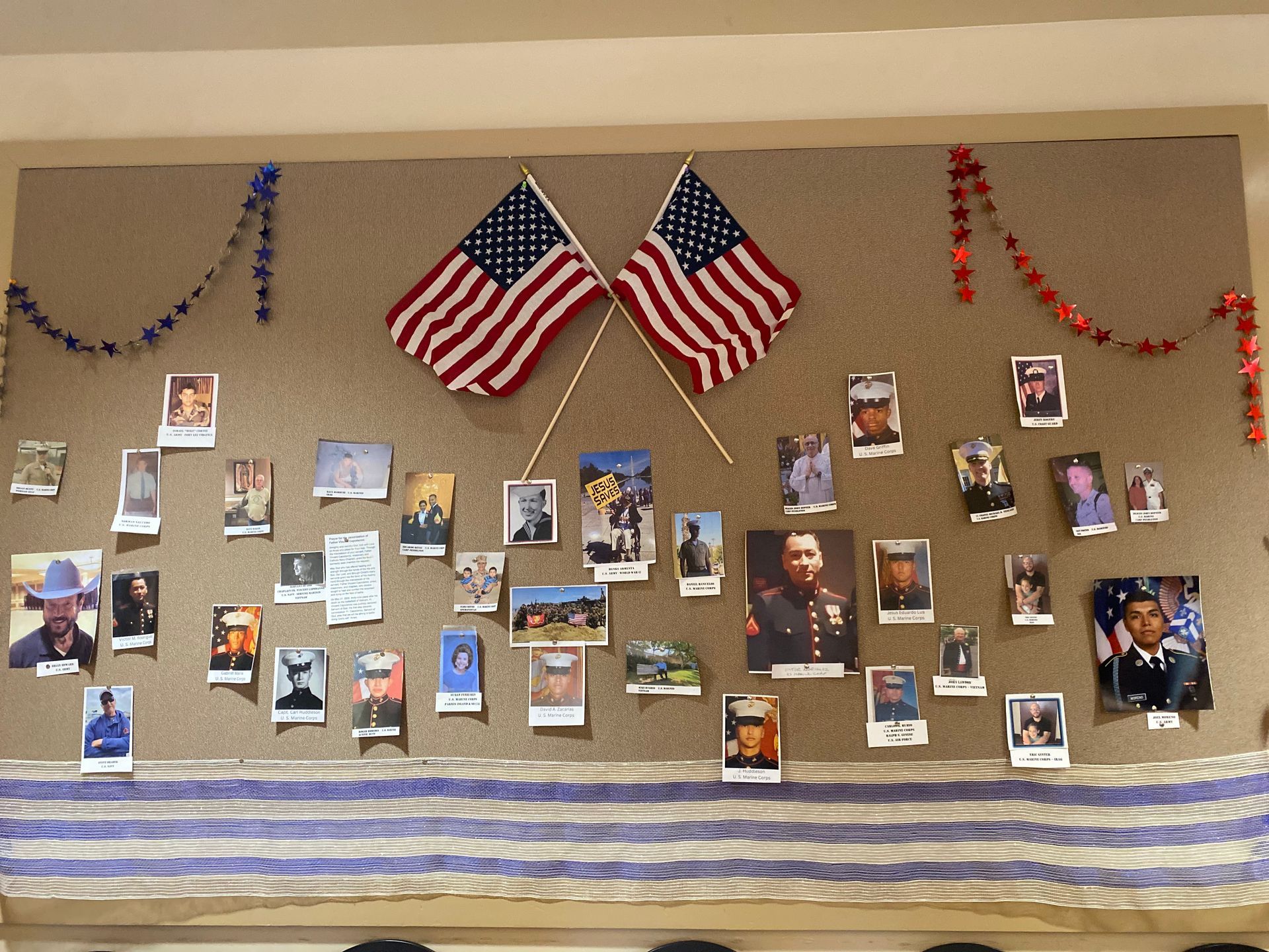 Memorial display board with American flags, photos, and patriotic blue-and-white decorations