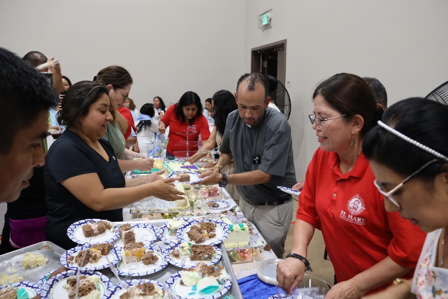 People sharing pastries at a table, with plates of snacks in a bright indoor room.