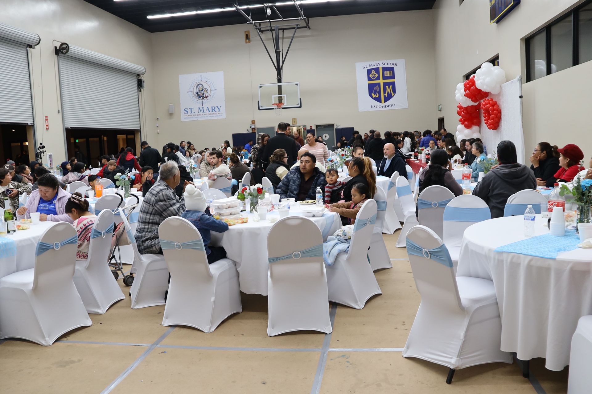 Banquet hall with round tables and seated guests at a festive indoor gathering