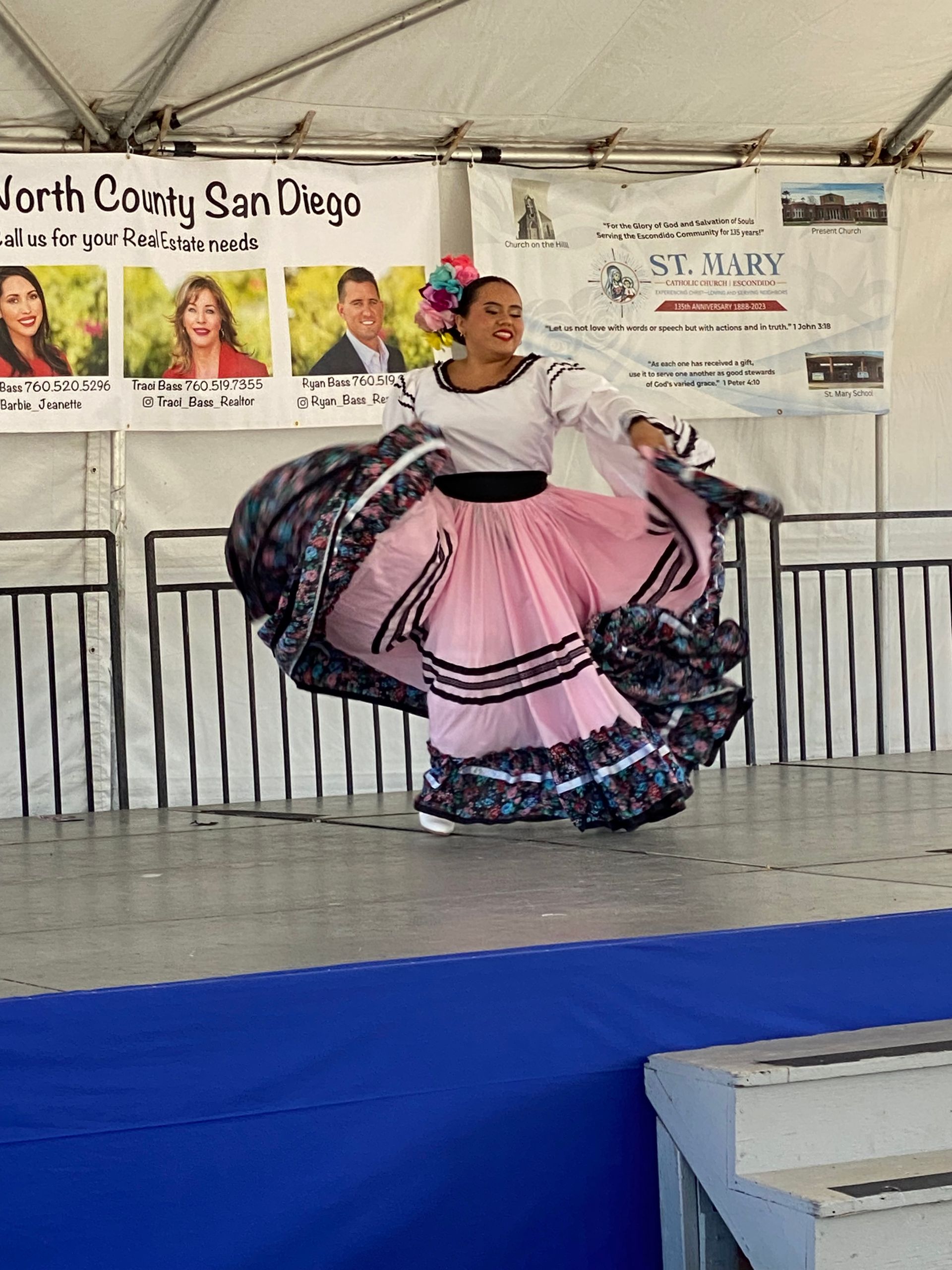 Dancer in pink and black dress performing on stage at a San Diego event
