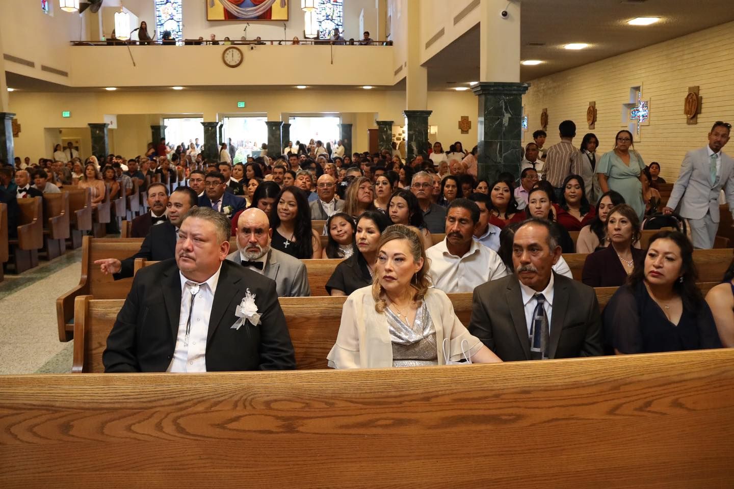 Congregation seated in a church, facing forward during a service or ceremony.