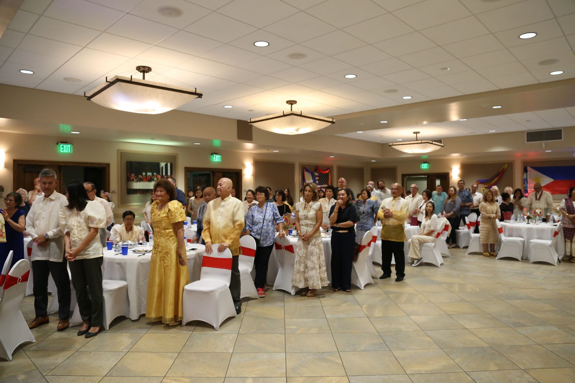 Guests standing and clapping in a banquet hall during a formal event