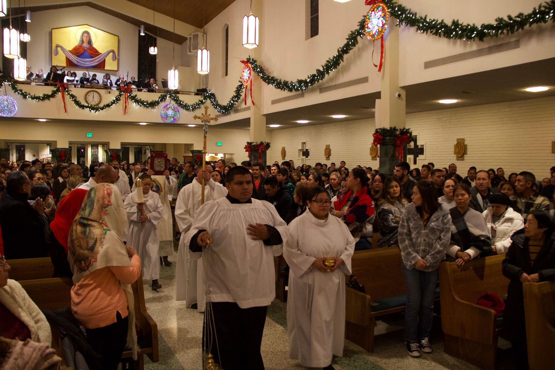 Congregants walking down a decorated church aisle during a service