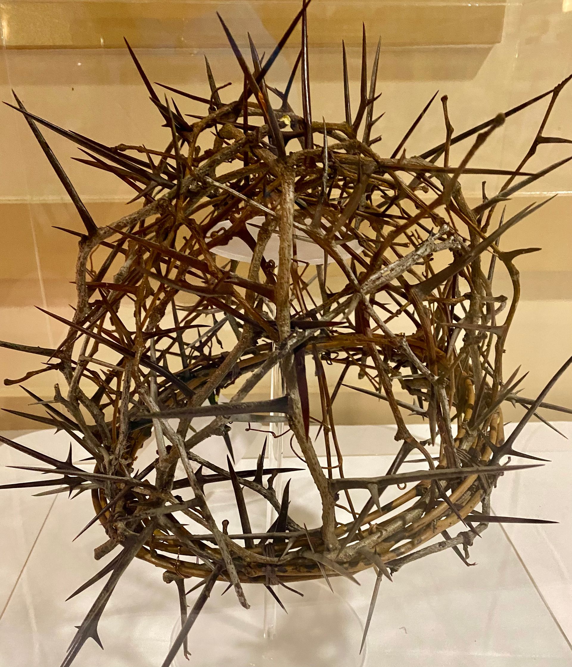 Spiky brown crown-like sculpture made of intertwined branches on a tiled floor