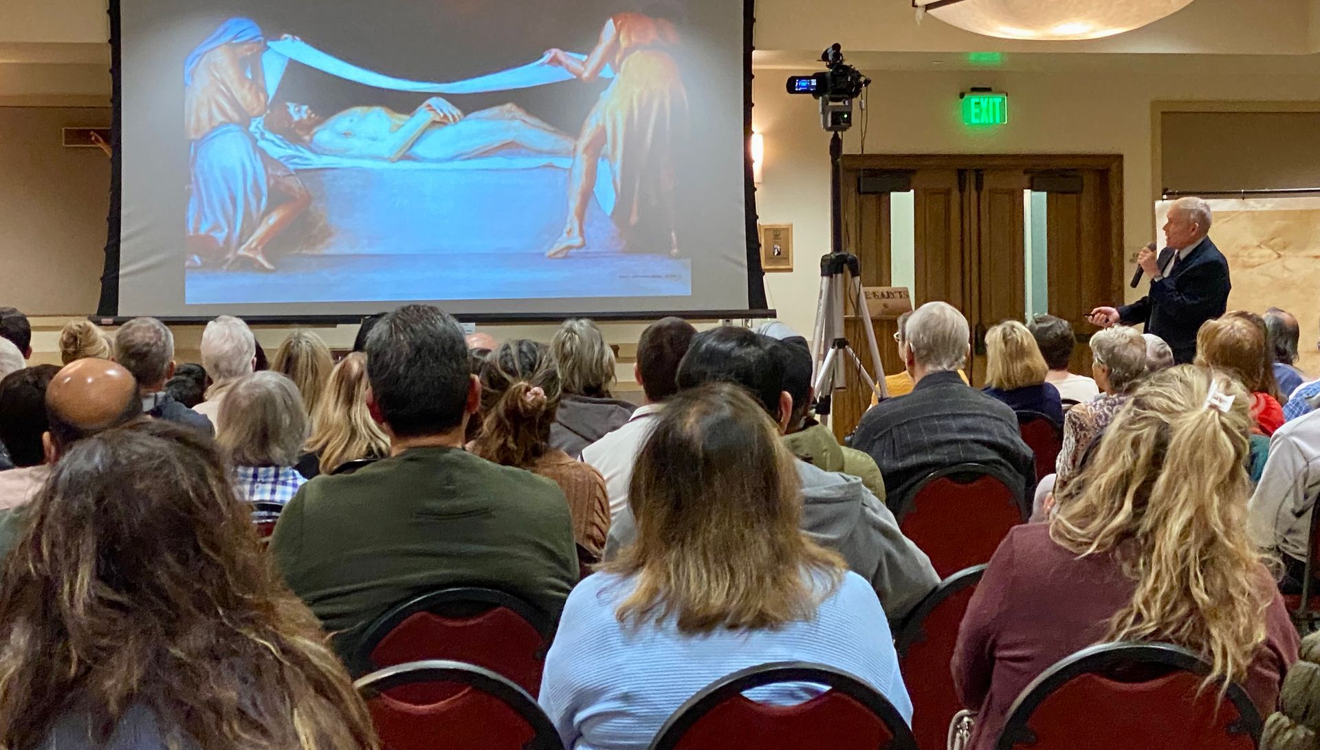 Audience watching a presentation on a projected slide in a conference room