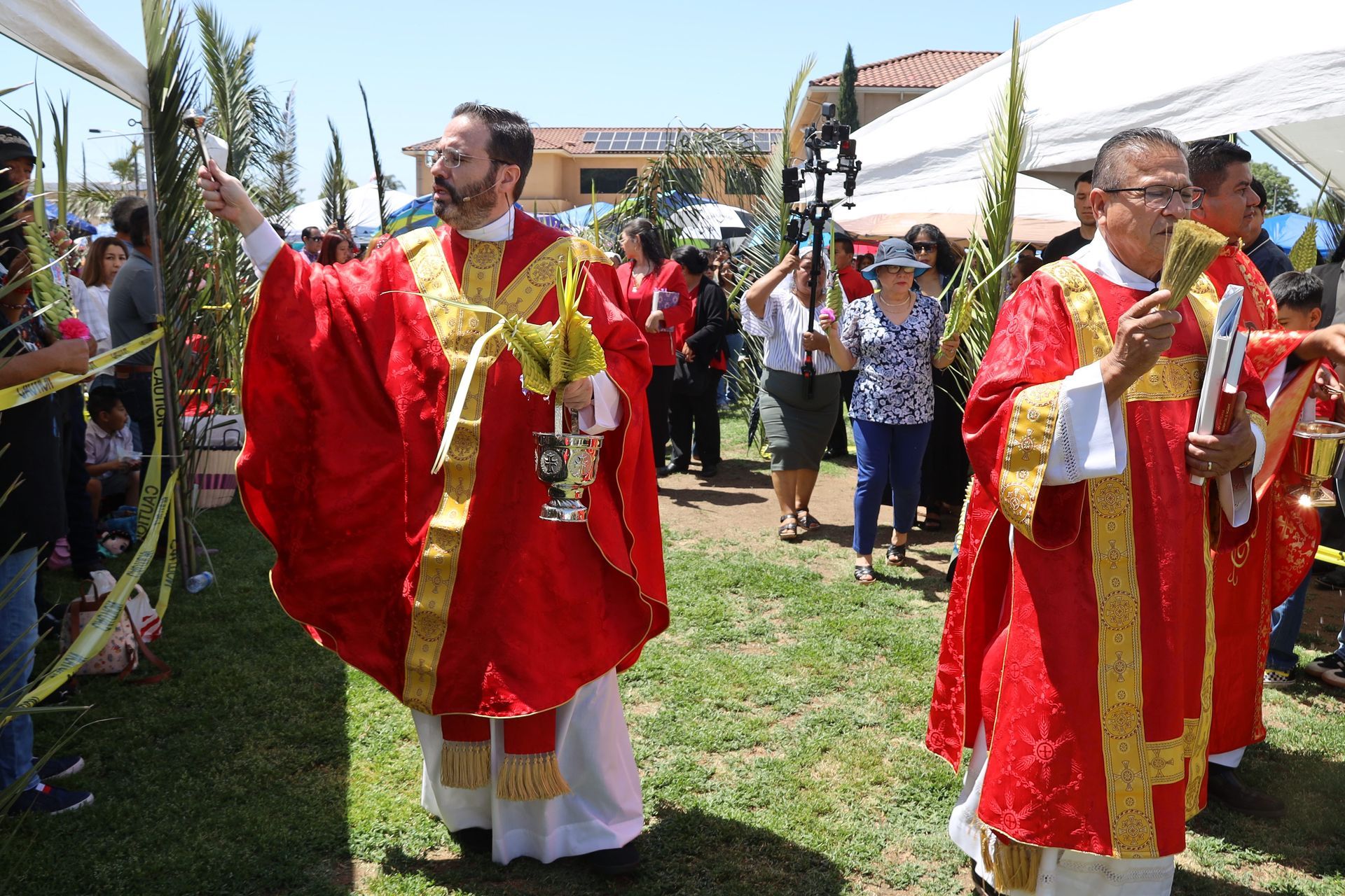 People in red and gold robes processing outdoors at a religious festival